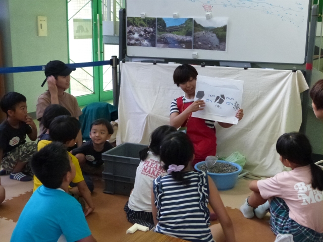 川の石の大きさの違いの説明を聞く子どもたち